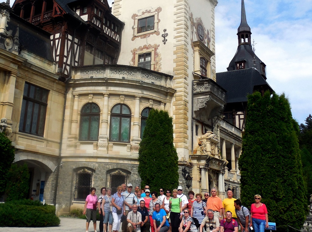 Uczestnicy wycieczki na tle zamku  Peles        
